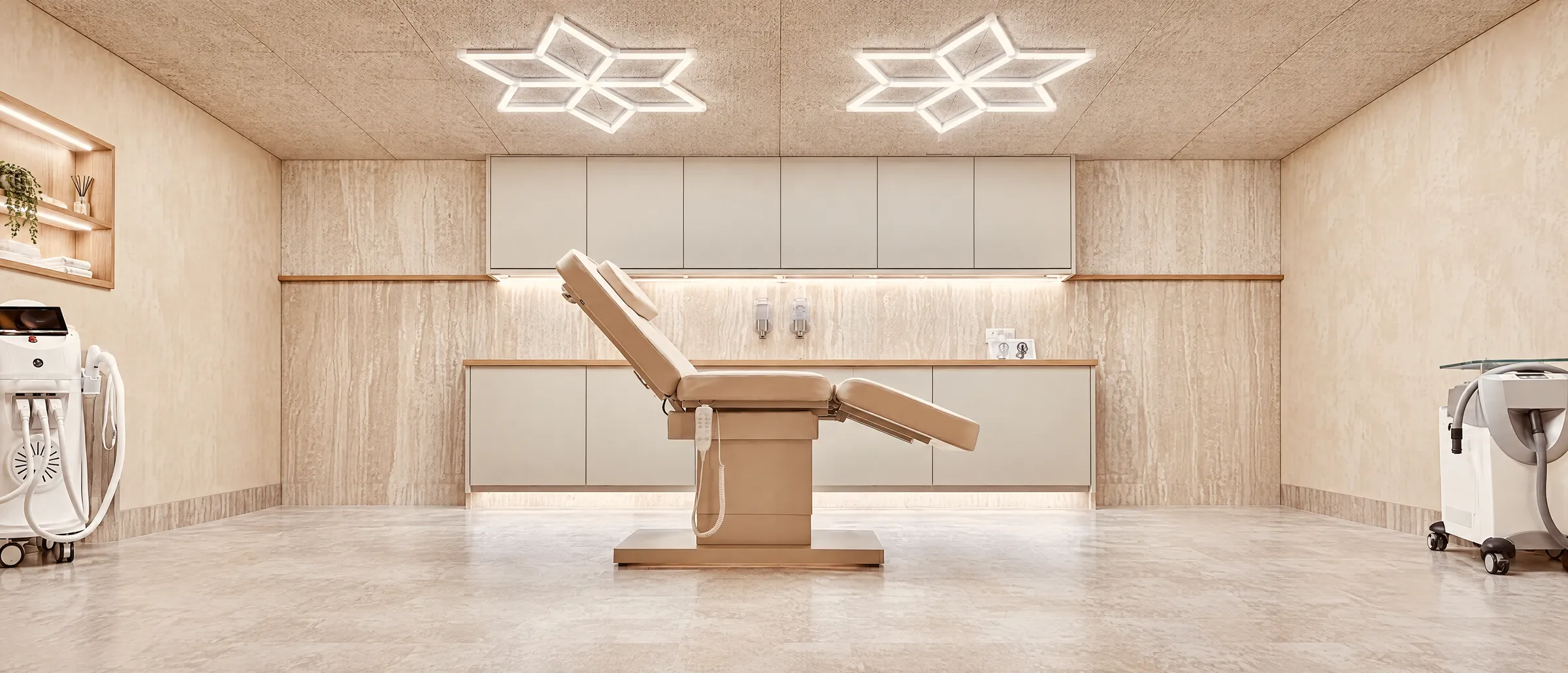 The Oliver J treatment room in Leigh-on-Sea: cream leather chair, travertine walls and star-shaped ceiling lights